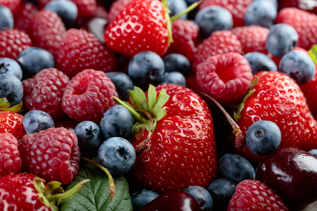 Berries closeup colorful assorted mix of strawberry, blueberry, raspberry and sweet cherry .の写真素材