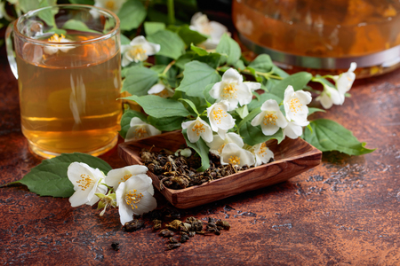 Green tea with jasmine in cup and teapot on old copper table.の写真素材