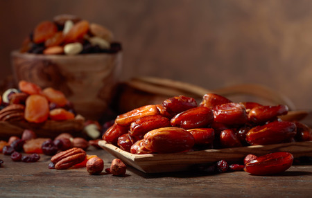 Various dried fruits and nuts on a old wooden table.の写真素材