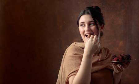 Portrait of a young beautiful girl with chocolate and candy. Copy space.の写真素材