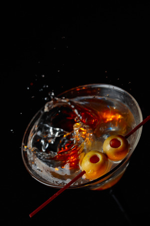 Martini cocktail with green olives on a black background. Copy space.の写真素材