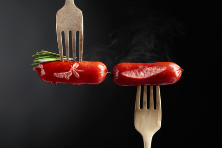 Grilled sausages with rosemary. Black background, copy space.の写真素材