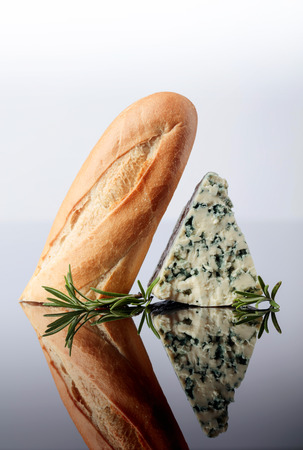 Blue cheese with bread and rosemary on a  reflective background. Copy space for your text.の写真素材