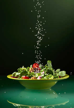 Green salad with cherry tomatoes, walnuts and vegetable oil sprinkle with sesame.の写真素材