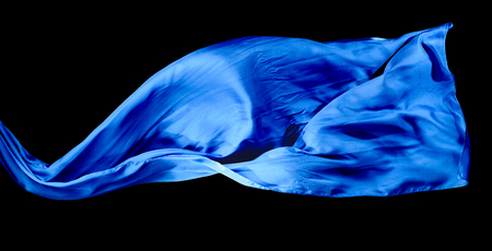 Smooth elegant blue transparent cloth isolated on black background. Texture of flying fabric.の写真素材