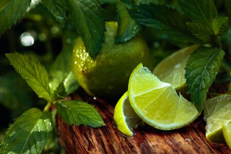 Wet growing mint in the garden and lime slices. Lime slices and mint leaves on an old wooden background.の写真素材