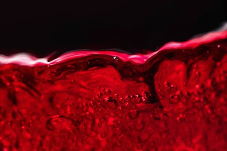 Red wine on black background, abstract splashing. Macro shot.の写真素材