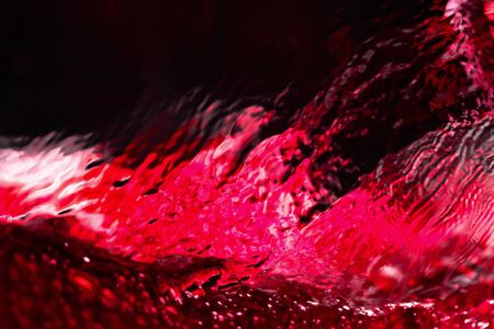 Red wine on black background, abstract splashing. Macro shot.