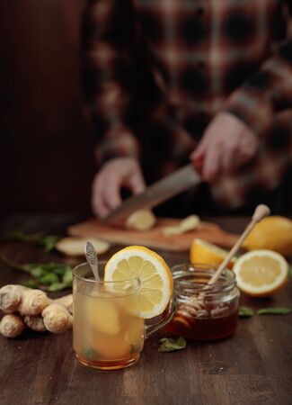 Cup of ginger tea with honey , lemon and mint on old wooden table .  Selective focus .の写真素材