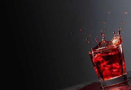 Cola glass with falling ice cubes on a dark background. Copy space.の写真素材