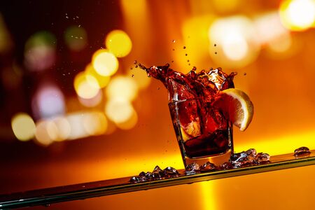 Slice of lemon falling into a glass of Cola. Cocktail with lemon. Copy space.の写真素材