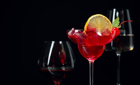 Various alcoholic drinks on a black background.  Brandy, cocktail and white wine on a black background. Copy space.の写真素材