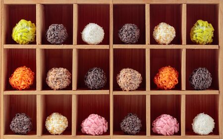 Various colorful chocolate candy in wooden box.の写真素材