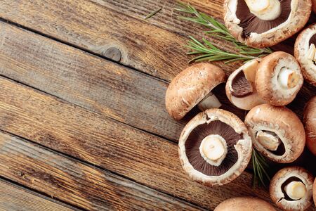 Fresh brown mushrooms champignon on a old wooden table. Copy space. Top view.の写真素材