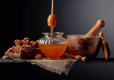 Healthy breakfast background. Honey and walnut on a black background,  copy space.の写真素材