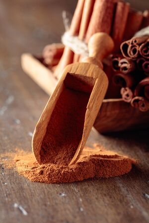 Cinnamon sticks and powder on a old wooden table.の写真素材