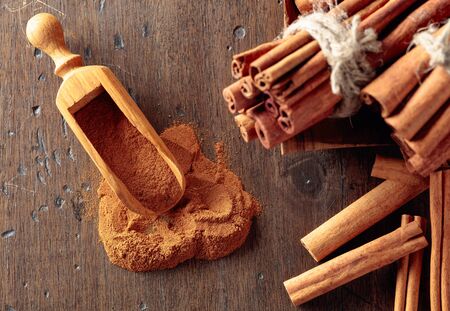 Cinnamon sticks and powder on a old wooden table.の写真素材