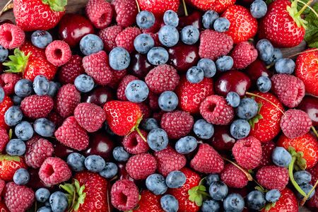 Berries closeup colorful assorted mix of strawberry, blueberry, raspberry and sweet cherry .の写真素材