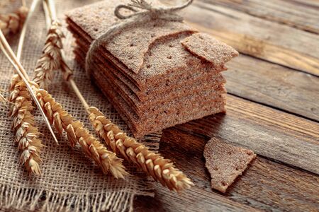Rye crackers and ears on a old wooden table. Healthy organic food.の写真素材
