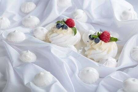 Dessert Pavlova with raspberries, blueberries and mint on a white fabric. の写真素材