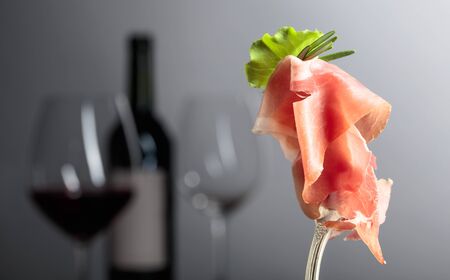 Prosciutto with rosemary and red wine on a grey background.の写真素材