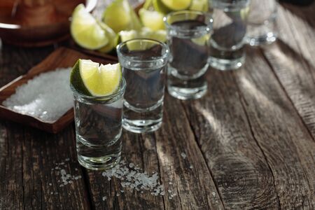 Tequila with sea salt and lime on a old wooden background.の写真素材