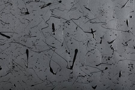 Black matte background with splashes and drops of glossy black paint.