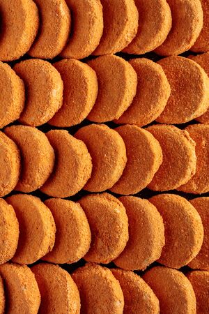 Frozen hamburger patties stacked in rows, top view.
