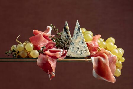 Grapes with blue cheese, prosciutto and thyme. Copy space.
