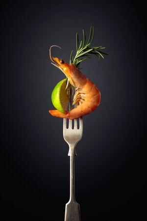 Shrimp with rosemary and lime on a black background. Copy space.の写真素材