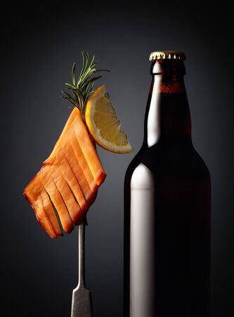 Bottle of beer and smoked squid with lemon slice.の写真素材