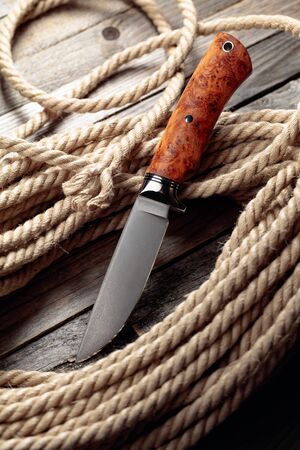 Hunter combat hand made knife and hemp rope. The blade has a beautiful damask pattern, handle - titan and elm.の写真素材