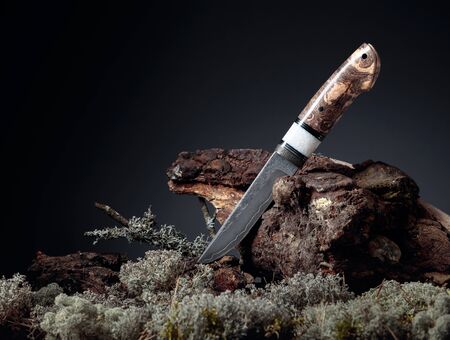 Hunter combat hand made knife. The surface of the blade - etching, traces of forging. Handle - inlace acrylester, Japanese maple. Copy space.の写真素材