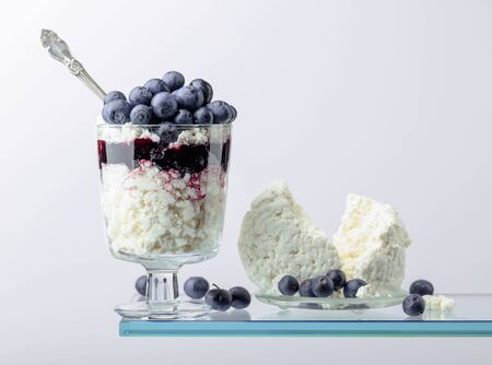 Cottage cheese with blueberry jam and fresh berries on a white background. Copy space.の写真素材