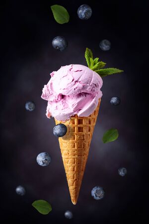 Blueberry ice cream with mint  in waffle cone.の写真素材