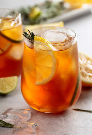 Traditional iced tea with lemon, lime and ice garnished with rosemary twigs. Frozen glasses with citrus slices.の写真素材