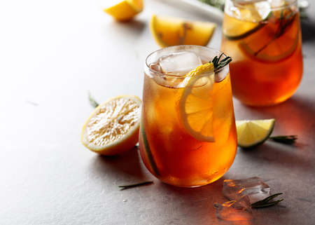 Traditional iced tea with lemon, lime and ice garnished with rosemary twigs. Frozen glasses with citrus slices. Copy space.の写真素材
