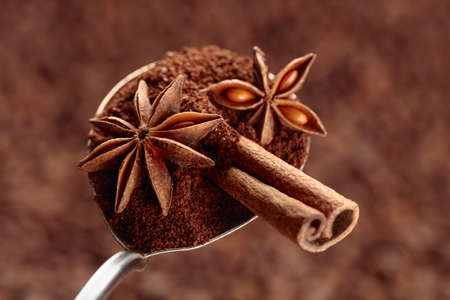 Spoon of ground coffee with anise and cinnamon on the background of coffee beans. Selective focus.の写真素材