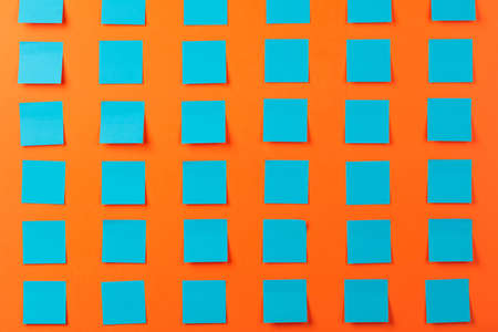 Blue empty stickers on a orange background. Free space for your text.