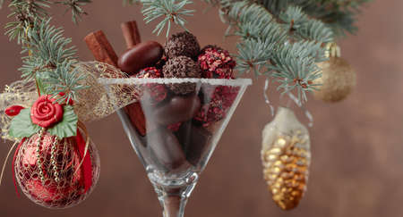 Assortment of fine chocolate candies in goblet. Christmas decoration with cinnamon sticks and chocolate. Still life of Christmas holidays. Copy space.の写真素材