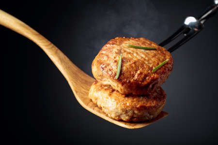 Delicious hot homemade cutlets with rosemary on a black background. Copy space.の写真素材