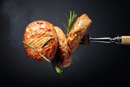 Delicious homemade cutlets with rosemary on a black background.の写真素材