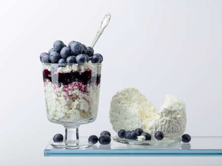 Cottage cheese with blueberry jam and fresh berries on a white background. Copy space.の写真素材