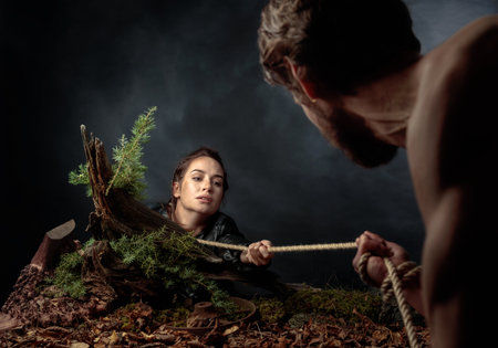 The young man rescues the girl by pulling her out by the rope. The image on the theme of the...