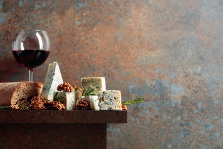 Blue cheese with walnuts, bread and rosemary on a rusty table. Copy space.の写真素材