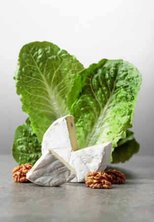 Fresh Brie cheese with lettuce and walnuts. Copy space.の写真素材