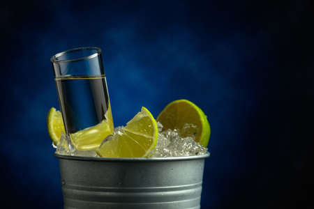 Strong alcoholic drink with lime slices in a metal bucket with ice.の写真素材