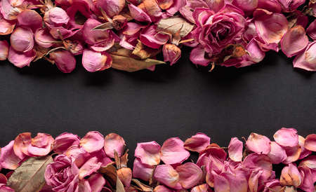 Flowers composition. Frame made of dried rose flowers, petals, and leaves. Top view with copy space.