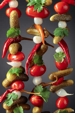 Preserved vegetables. Marinated cucumbers, tomatoes, peppers, and onions garnished with green coriander leaves.の写真素材