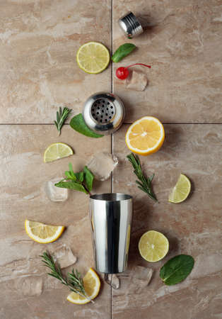 Shaker with ingredients for making cocktails. Brown ceramic table. Top view.の写真素材